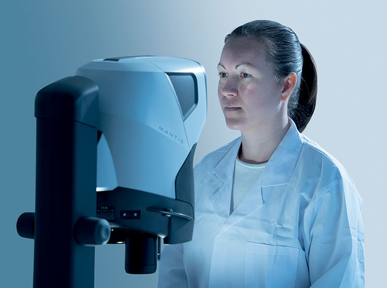 Mujer mirando a través del microscopio estereoscópico sin ocular Mantis